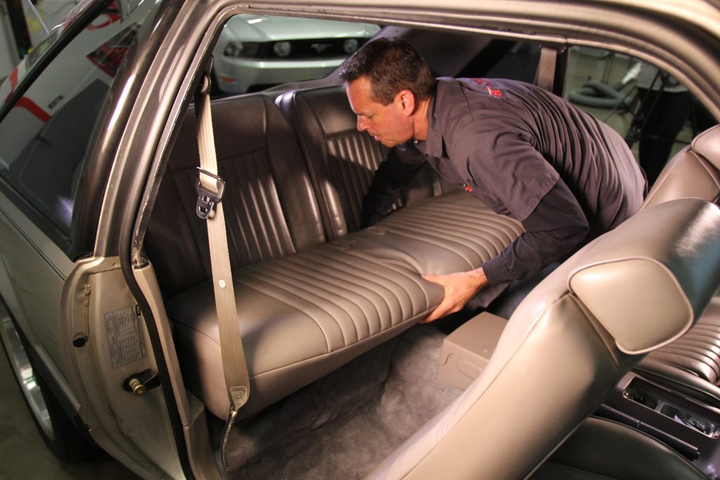 man removing back set of a car