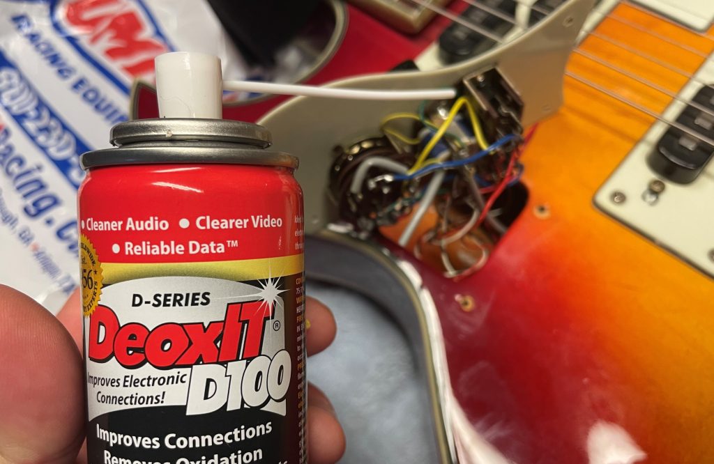 caig deoxit d100 near guitar on workbench